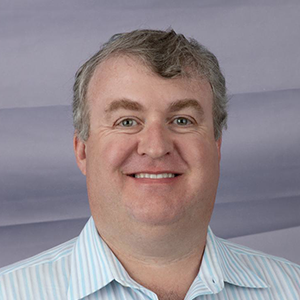 Tim Callan headshot in collared shirt